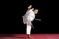 Karate boy in white kimono fighting isolated on black background Royalty Free Stock Photo