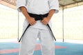 Karate coach wearing kimono and black belt at outdoor gym, closeup