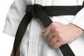 Karate coach wearing kimono and black belt on white background, closeup