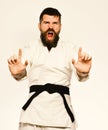 Karate man with angry face in uniform. Oriental sports concept. Jiu Jitsu master with black belt Royalty Free Stock Photo