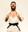 Karate man with angry face in uniform. Oriental sports concept.