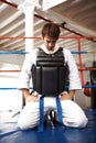 Karate, man and kneeling, exercise with fight in ring and martial arts, protection vest with prayer and ready for battle Royalty Free Stock Photo