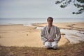 Karate man in an old kimono and black belt meditating at the sea. Martial arts concept. Royalty Free Stock Photo