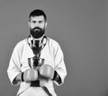 Karate man with serious face in boxing gloves holds cup Royalty Free Stock Photo