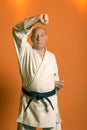 A karate man in a white kimono with a black belt is training. Royalty Free Stock Photo