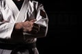 Karate master proudly clutches black belt, symbolizing expertise and mastery