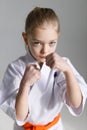 Karate stance defense, portrait of a serious fighting girl on a white background