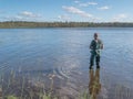 Man fishing with spinning in lake. Ecotourism, visiting fragile, pristine, undisturbed natural