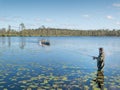 Young man fishing with spinning in a lake. Ecotourism, visiting fragile, pristine, undisturbed