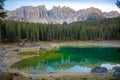 Karersee or Lago di Carezza, is a lake with mountain range of the Latemar group on background in the Dolomites in Tyrol