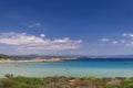 Karidi beach visitors, mostly families with liittle children, swim in the shallow, transparent, azure-colored water of Vourvourou