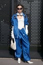 Karina Nigay with blue sweatsuit, silver headphones and sunglasses before Gucci fashion show,