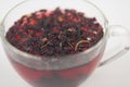 Tea drink in a glass. Red liquid in a glass. Dried petals. Hibiscus. Sudanese rose