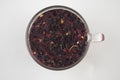 Tea drink in a glass. Red liquid in a glass. Dried petals. Hibiscus. Sudanese rose
