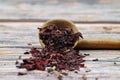 Karkade tea. Hibiscus tea leaves in wooden spoon isolated on wooden background. File contains clipping path. Top view. Selective