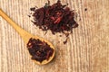 Karkade tea. Hibiscus tea leaves in wooden spoon isolated on wooden background. File contains clipping path. Top view. Selective