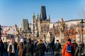 Karlov or Charles bridge with Lesser Town bridge tower and baroque Church of St. Nicholas, city landmark at sunny winter day,