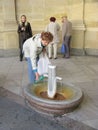 KARLOVY VARY, CZECH REPUBLIC. Woman picks up water in a bottle from a mineral source