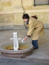 KARLOVY VARY, CZECH REPUBLIC. Woman picks up water in a mug from a mineral source