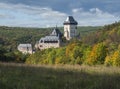 Karlstejn gothic state castle near Prague, the most famous castle in Czech Republic with grass meadow and autumn colored trees and