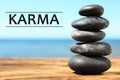 Karma concept. Stack of stones on wooden surface against seascape Royalty Free Stock Photo