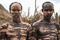 Several men from the Caro tribe pose in front of the camera for a group photo.