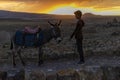 Kars, Turkey 07.22.2021; A peasant boy watching the sunset with his donkey. Royalty Free Stock Photo