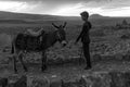 Kars, Turkey 07.22.2021; A peasant boy watching the sunset with his donkey. Royalty Free Stock Photo