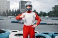 Kart driver in helmet, karting track on background