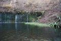Karuizawa Shiraito waterfalls peaceful natural area featuring a small arc-shaped waterfall framed by mountain slopes in Novermber