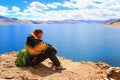 KARZOK, LADAKH, INDIA - 18 AUG 2015: Unidentified man sits on the shore of Lake Tso Moriri and looks at the water.