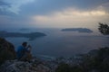 Kas view point, Turkey, Man sitting and taking photo with compact camera from viewpoint above Kas town of Mediterranean sea Royalty Free Stock Photo