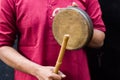 Kasar or gong bell being performed or hit with wooden stick by Indian male in traditional attire during hindu puja rituals. Kasar