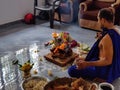 An Indian Hindu priest or Brahmin men doing Pooja or pray Ganapathi homam in the home with materials and vegetable food items