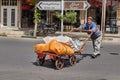 Elderly man pushes forward a overflowing handcart, Kashan, Iran.