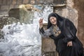Iranian lady at a waterfall, splashing water