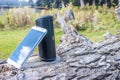 Kashmir, India: Dated: July 31, 2019- A smartphone and a JBL Bluetooth Portable Speaker kept on a log of wood outdoors Royalty Free Stock Photo