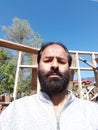 An kashmiri elder man in front of under construction house