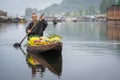 Kashmiri merchants with old wooden boat paddle for selling flowers to tourists in Dal Lake, at Houseboat is the famous place of