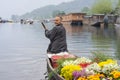 Kashmiri merchants with old wooden boat paddle for selling flowers to tourists in Dal Lake, at Houseboat is the famous place of