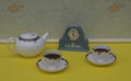 Pale blue Wedgwood watch, Jasperware, with applied relief plate of white clay, next to english teacups and saucers and teapot Royalty Free Stock Photo