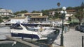 Fishing boots and yachts moored in the harbour of the tourist village of Kassiopi in the north of the island of Corfu