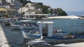 Fishing boots and yachts moored in the harbour of the tourist village of Kassiopi in the north of the island of Corfu