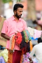 Street seller carrying handmade fabric chains in the hands, People on the streets of