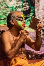 Kathakali exponent preparing for performance by applying face make-up. Kathakali is the classical dance form of Kerala