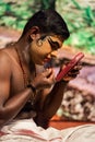 Kathakali exponent preparing for performance by applying face make-up. Kathakali is the classical dance form of Kerala