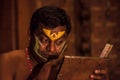 Kathakali exponent preparing for performance by applying face make-up