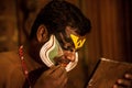 Kathakali exponent preparing for performance by applying face make-up