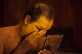 Kathakali exponent preparing for performance by applying face make-up