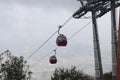 A cable car is moving uphill on the wired ropeway for tourists to visit mountain top on a popular tourist destination. Royalty Free Stock Photo